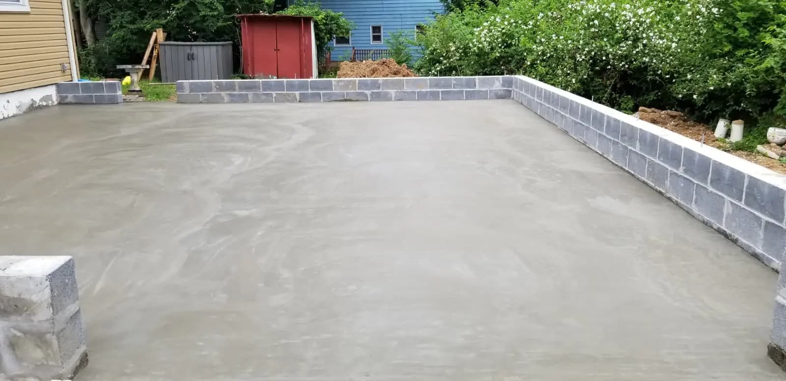 Level concrete surface bordered by a low concrete-block retaining wall